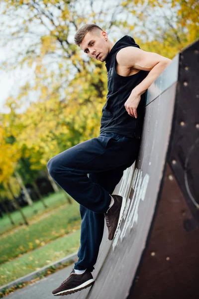 Portret faceta pewnie fitness. Człowiek stwarza na rampa, na tle jesień las. Upadek. — Zdjęcie stockowe