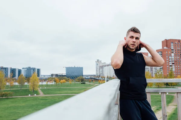 Sport fitness man poserar mot bakgrund av staden. Manliga idrottare utanför hösten park. Passar modell. — Stockfoto