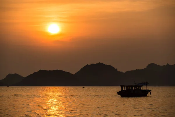 Barcos de pesca asiáticos ao pôr do sol em um fundo de montanhas . — Fotografia de Stock