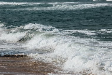 Dalgalar kıyıya köpük, dalga armalar yakınındaki