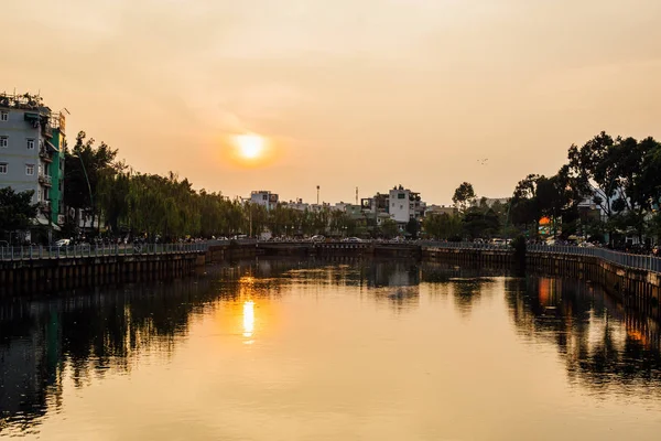 Casas en territorio con árboles, río reflejándose en el agua, s —  Fotos de Stock