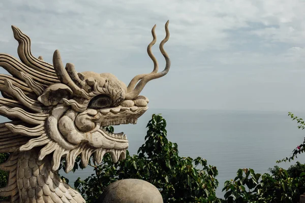 Азиатский дракон из белых камней на заднем плане моря — стоковое фото