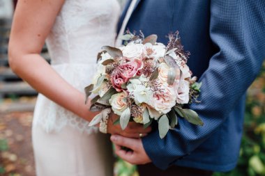 Gelin ve damat birlikte düğün buketi tutan, açık