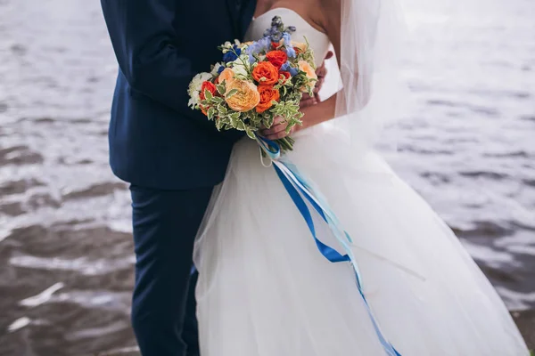 Novia y novio celebrando ramo de boda juntos, al aire libre, ver o — Foto de Stock