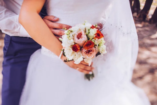 Novia y novio celebrando ramo de boda juntos, al aire libre . Imagen De Stock