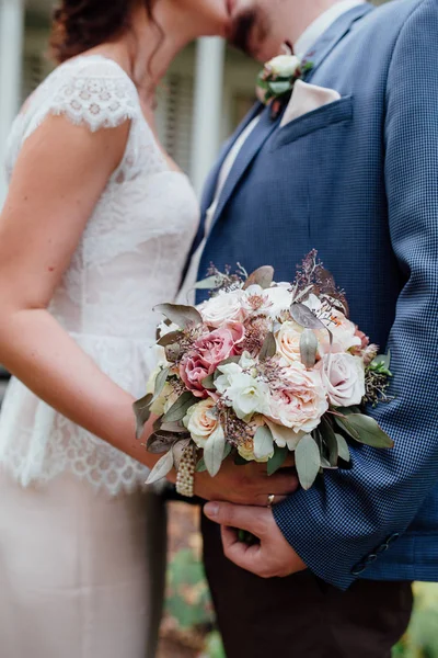Nevěsta a ženich Polibte si navzájem držku svatební kytice Royalty Free Stock Obrázky