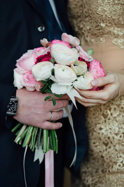 Nevěsta a ženich držící svatební kytici společně, venkovní Royalty Free Stock Obrázky