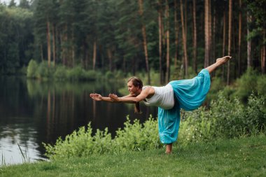 hamile yoga doğum öncesi analık farklı egzersizleri yapıyor. parkta çim, nefes, germe, statik.