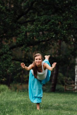 hamile yoga doğum öncesi analık farklı egzersizleri yapıyor. parkta çim, nefes, germe, statik.