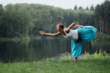 hamile yoga doğum öncesi analık farklı egzersizleri yapıyor. parkta çim, nefes, germe, statik.