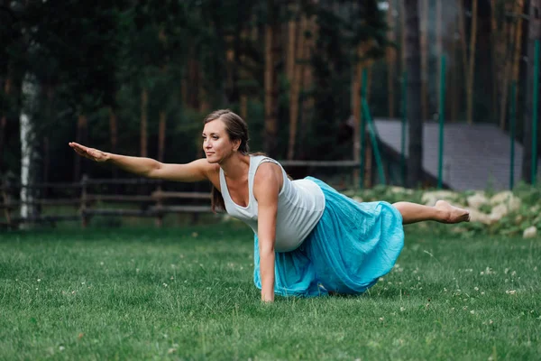 Pregnant yoga prenatal maternity doing different exercises. in the park on the grass, breathing, stretching, statics. — Stock Photo, Image