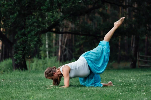 Joga w ciąży macierzyństwo prenatalne różnych ćwiczeń. w parku na trawie, oddychanie, rozciąganie, Statyka. — Zdjęcie stockowe