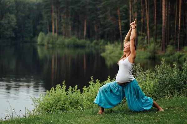 Беременная йога предродовое материнство делать различные упражнения. в парке на траве, дыхание, растяжка, статика . — стоковое фото