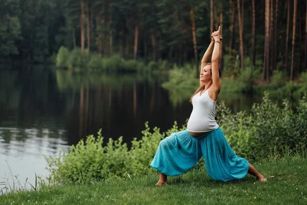 Беременная йога предродовое материнство делать различные упражнения. в парке на траве, дыхание, растяжка, статика . — стоковое фото