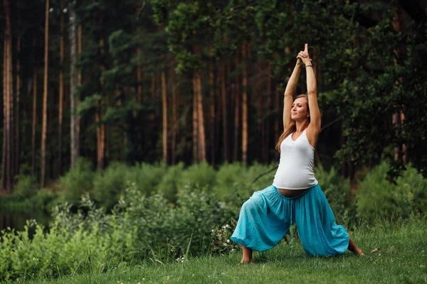 Hamile yoga doğum öncesi analık farklı egzersizleri yapıyor. parkta çim, nefes, germe, statik. — Stok fotoğraf