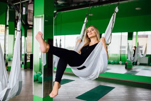 Uzun saçlı sarışın ile doğal bir sevimli güzel kız mekeup sanatçı portresi. Stüdyo, anti yerçekimi fitness yoga .