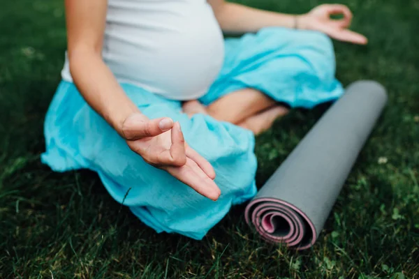 Nefes, germe, statik hamile yoga kadınla lotus pozisyonunda Park çimenlerin üzerinde mat portre. — Stok fotoğraf