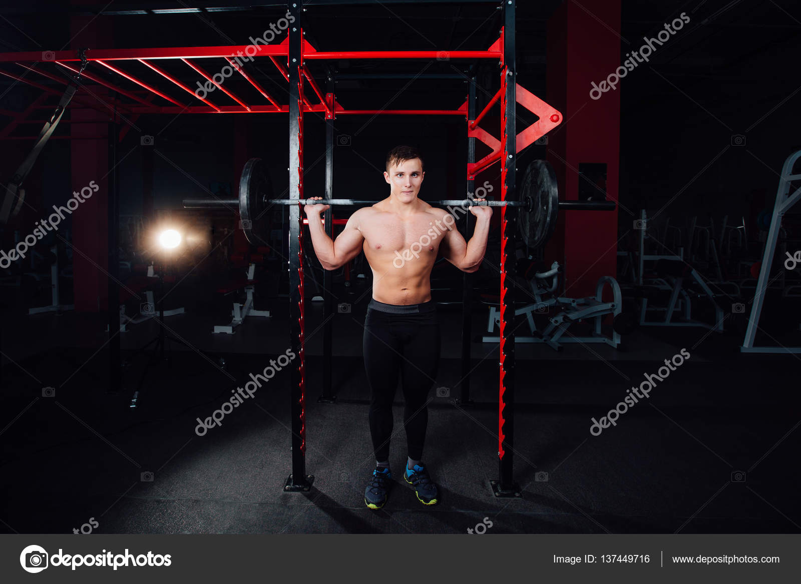 Retrato de un atleta guapo en el gimnasio. hombre hace el ejercicio con la  barra, de pie y en cuclillas. gran confianza: fotografía de stock ©  photominus #137449716
