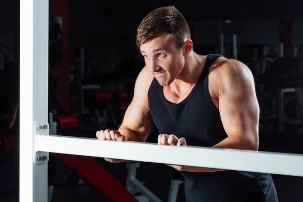 Portret uśmiechający się mięśni młody człowiek robi ćwiczenia Push up na tle siłowni. ciężkich treningów, emocje — Zdjęcie stockowe