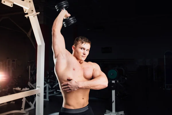 Primer plano retrato de culturista profesional Fuerte hombre yang muscular haciendo ejercicio. Entrenamiento con barra en el gimnasio. Deportes y fitness. Entrenador bombeando manos tríceps . —  Fotos de Stock