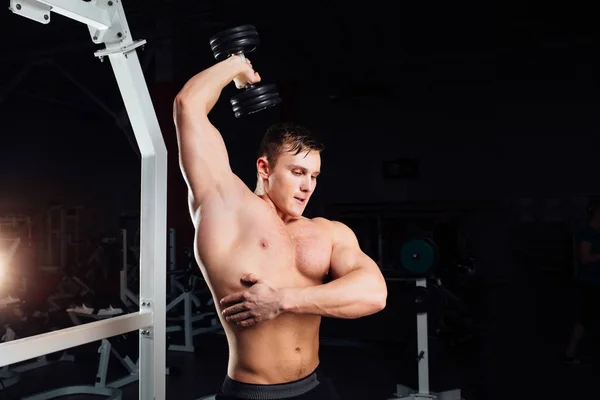 Closeup portret van professioneel bodybuilder sterke gespierde yang man doen oefening. Training met barbell op sportschool. Sport en fitness. Opleiding kerel oppompen van handen triceps. — Stockfoto