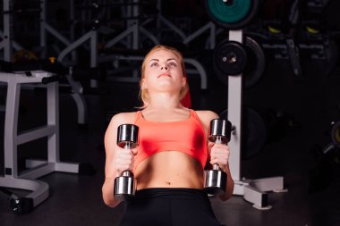seksi kız onun pektoral kas egzersizleri yapıyor. fitness salonunda dumbbells ile. güzel şirin erkek.