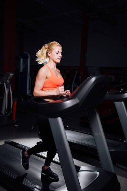 Genç güzel şirin kız şişe ile koşu bandı üzerinde çalışan spor salonunda fitness modeli