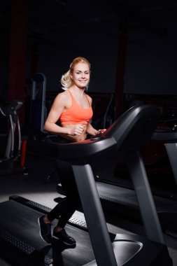 Genç güzel şirin kız şişe ile koşu bandı üzerinde çalışan spor salonunda fitness modeli