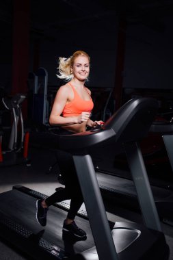 Genç güzel şirin kız şişe ile koşu bandı üzerinde çalışan spor salonunda fitness modeli