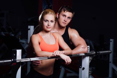 Atletik çift - erkek ve kadın arasında egzersiz halter salonunda yakınındaki dinlenme