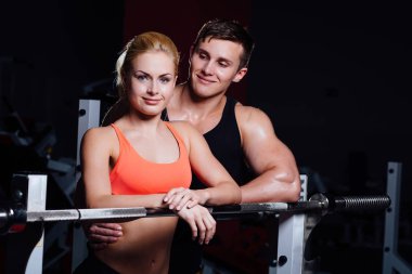 Atletik çift - erkek ve kadın arasında egzersiz halter salonunda yakınındaki dinlenme