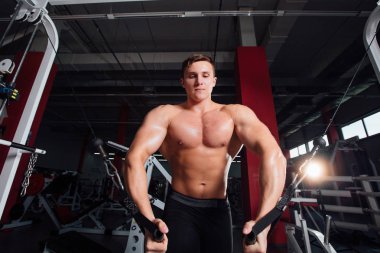 büyük güçlü bodybuider gömlek olmadan crossover egzersizleri göstermektedir. Göğüs kasları ve zor eğitim