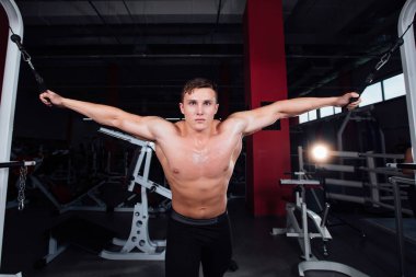 büyük güçlü bodybuider gömlek olmadan crossover egzersizleri göstermektedir. Göğüs kasları ve zor eğitim