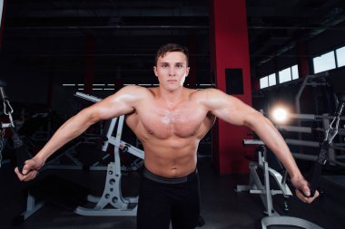 büyük güçlü bodybuider gömlek olmadan crossover egzersizleri göstermektedir. Göğüs kasları ve zor eğitim