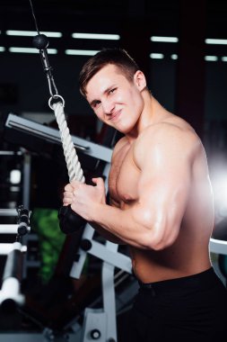 büyük güçlü bodybuider gömlek olmadan crossover egzersizleri göstermektedir. Göğüs kasları ve zor eğitim