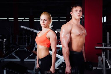 kas gösterilen ve beğenilen sırasında spor salonunda dumbbells ile poz güzel genç sportif Çift