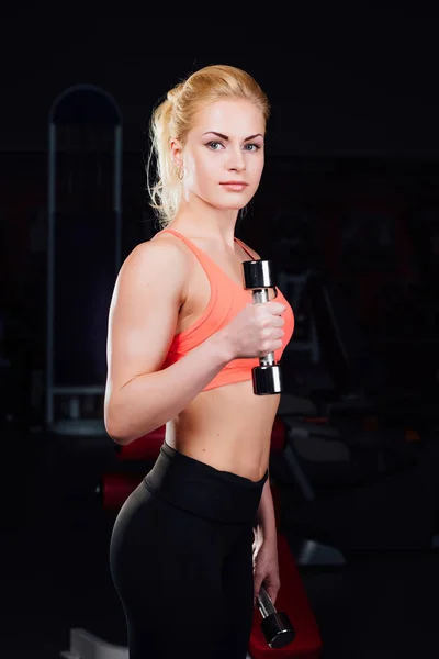 Gyakorolja az ő szexi lány fegyverek a bicepsz és a tricepsz. a súlyzó az edzőteremben fitness. — Stock Fotó