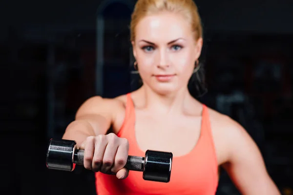 Chica sexy haciendo ejercicios en sus brazos bíceps y tríceps. fitness con pesas en el gimnasio . — Foto de Stock