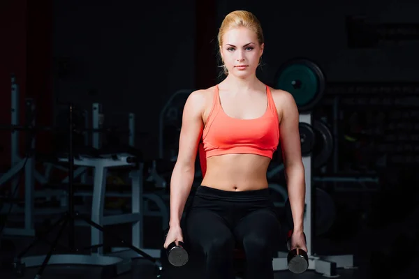 Sexy dziewczyna robi ćwiczenia w jej ramionach biceps i triceps. fitness z hantlami w siłowni. — Zdjęcie stockowe