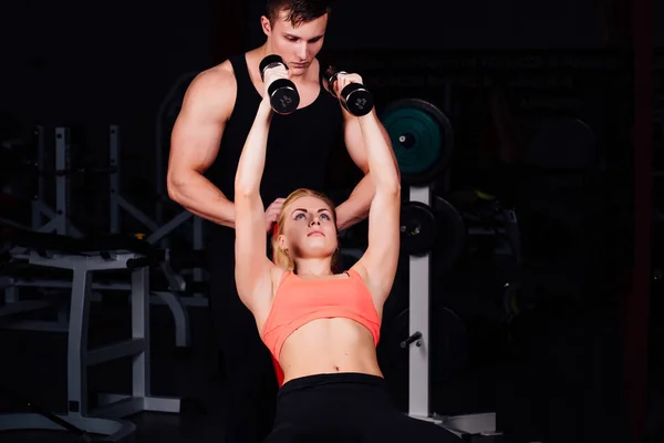 Instructor de fitness haciendo ejercicio con su cliente en el gimnasio. — Foto de Stock