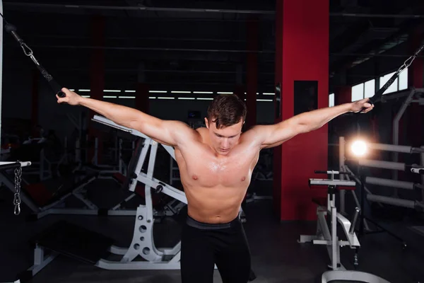 Gran bodybuider fuerte sin camisas demuestran ejercicios crossover. Los músculos pectorales y el entrenamiento duro —  Fotos de Stock