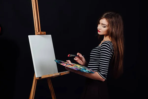 Słodkie dziewczyny piękne artysta malarstwo obraz na płótnie sztalugach. Miejsca na tekst. Studio czarne tło. — Zdjęcie stockowe