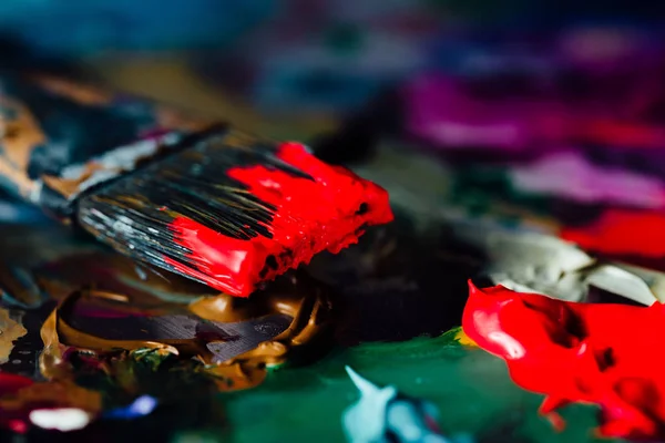 Художественная кисть смешанной краски на палитре. Инструменты художника, окрашенные в чернила после работы . — стоковое фото