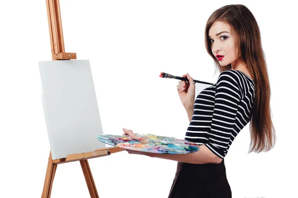 かわいい美少女アーティスト キャンバス イーゼルの絵を描きます。テキストのためのスペース。スタジオ白い背景、分離. — ストック写真