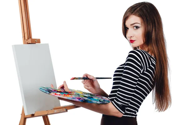 Χαριτωμένο κορίτσι όμορφο καλλιτέχνη ζωγραφικής μια εικόνα σε καμβά καβαλέτο. Χώρο για το κείμενο. Studio λευκό φόντο, απομονωμένο. — Φωτογραφία Αρχείου