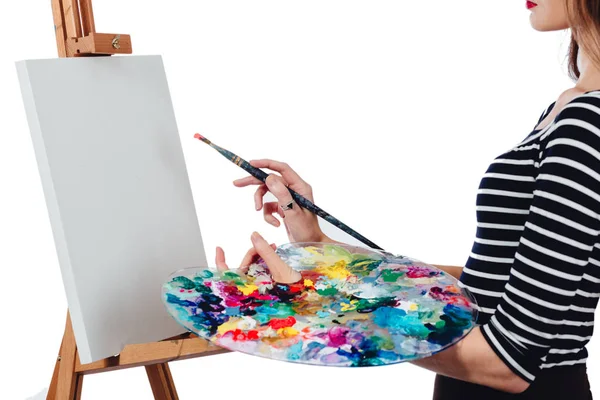 Schattige mooie meisje kunstenaar schilderen van een foto op canvas ezel. Ruimte voor tekst. Studio witte achtergrond, geïsoleerd. — Stockfoto
