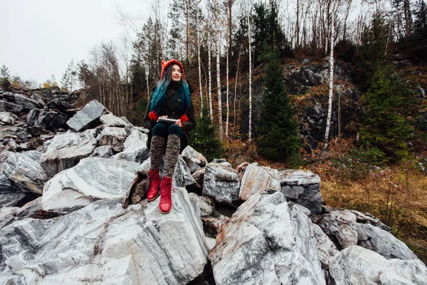 Artist girl painting sitting on the rocks at the cliff, notepad. Wonderful fall view — Stock Photo, Image