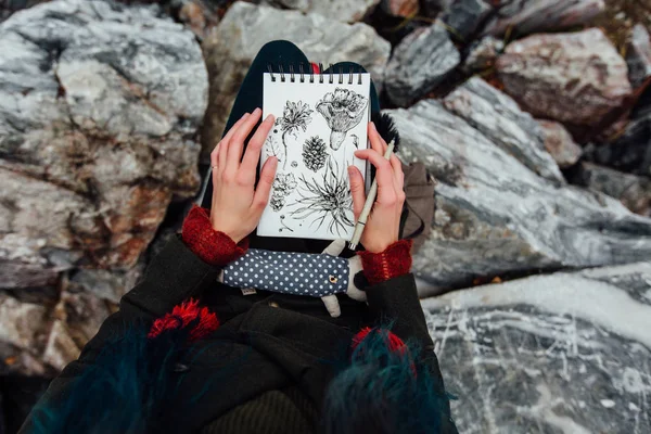 Artista chica pintura sentado en las rocas en el acantilado, bloc de notas. Maravillosa vista otoño — Foto de Stock