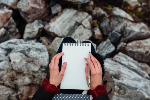 Artista chica pintura sentado en las rocas en el acantilado, bloc de notas. Maravillosa vista otoño — Foto de Stock