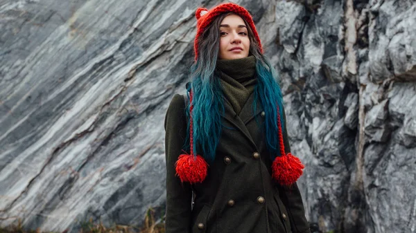 Retrato de una hermosa chica hipster en el fondo los acantilados rocosos. Pelo teñido, azul, largo . —  Fotos de Stock